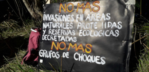 Cartel que dice «No más invasiones en áreas naturales protegidas. No más grupos de choque»